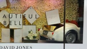 A window display, featuring a realistic looking vintage car back and retail boxes stacked next to and atop the vehicle