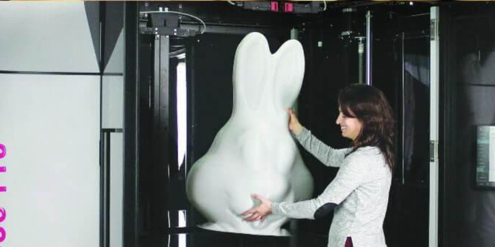 Woman removing a huge 3d printed bunny from Massivit's 1800 Pro additive manufacturing technology