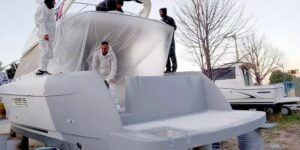 Image of a 3D printed boat with 4 people working on it by Velum Nautica of Croatia